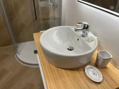 a bathroom with a white sink and a shower at My Dolomites Home in Livinallongo del Col di Lana
