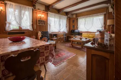 a kitchen with a table and a living room at Casa vacanze 5 Torri in Cortina dʼAmpezzo