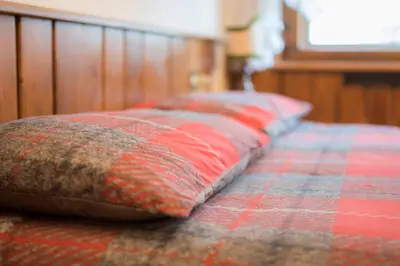 a bed with red and gray pillows on it at Casa vacanze 5 Torri in Cortina dʼAmpezzo