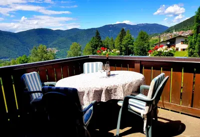 a table on a balcony with a view of mountains at Casa sulle nuvole in Montesover