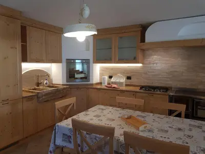 a kitchen with wooden cabinets and a table with chairs at Casa sulle nuvole in Montesover