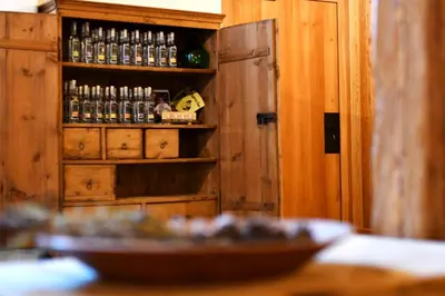 a table with a bowl of food in front of a shelf with bottles at Haidnerhof in Bressanone
