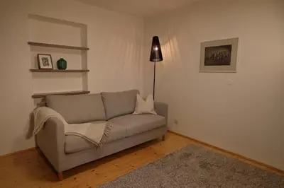 a living room with a couch and a lamp at Glögglhof in Lana