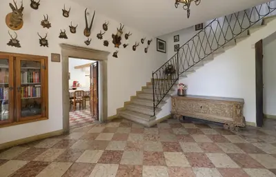 a living room with a staircase with antlers on the wall at Casa Bolego in Cagnò