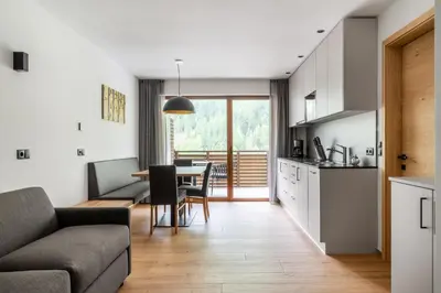 a white kitchen with white cabinets and a microwave at Apparthotel Sonnwies in Selva dei Molini