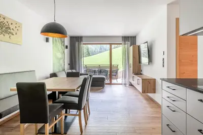 a kitchen and dining room with a table and chairs at Apparthotel Sonnwies in Selva dei Molini