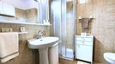 a white bathroom with a sink and a shower at Dolomiti Terrace Cavalese in Cavalese