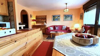 a kitchen and living room with a bowl of fruit on a table at Dolomiti Terrace Cavalese in Cavalese