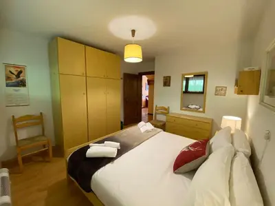a bedroom with a large bed and a chair at Dolomiti Terrace Cavalese in Cavalese