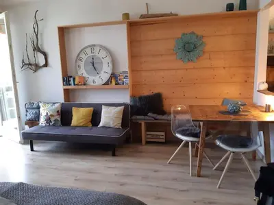 a living room with a couch and a clock on the wall at Appartement Pienzenau in Merano