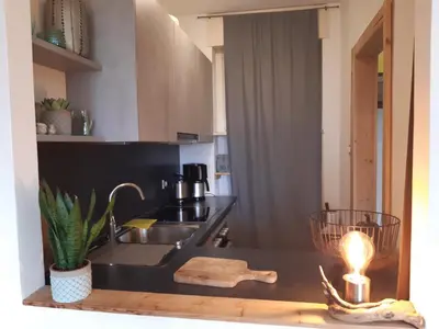 a kitchen with a sink and a table with a lamp at Appartement Pienzenau in Merano