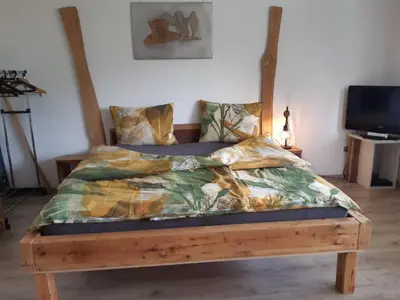 a bedroom with a bed with a wooden frame at Appartement Pienzenau in Merano