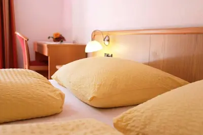 a bedroom with two yellow pillows on a bed at Gasthof Albergo Neuwirt in Val di Vizze