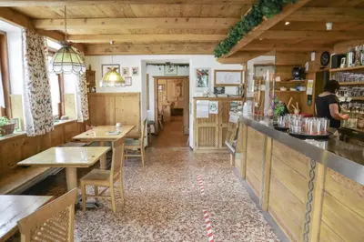 a restaurant with tables and a counter in a room at Gasthof Albergo Neuwirt in Val di Vizze