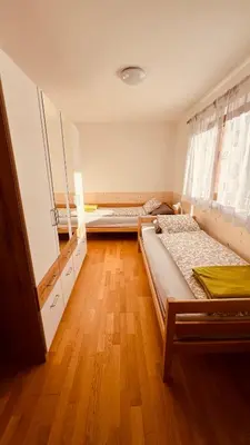 a bedroom with two beds and a wooden floor at Appartement Nadia in Bressanone