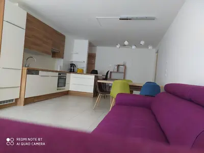 a living room with a purple couch and a kitchen at Appartement Nadia in Bressanone