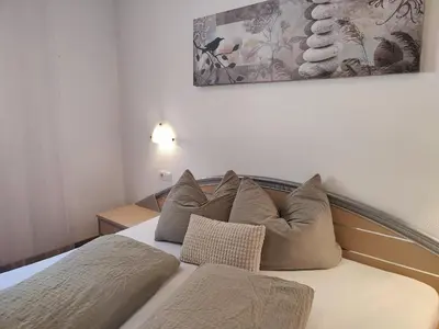 a bed with pillows on it in a room at Pramstaller Apartments in San Lorenzo di Sebato