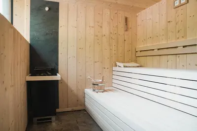 a sauna with wood paneled walls and a bench at Guesthouse Karnatsch in Parcines