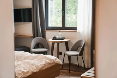 a bedroom with a table and two chairs and a bed at Guesthouse Karnatsch in Parcines