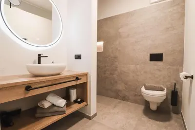 a bathroom with a sink and a toilet and a mirror at Guesthouse Karnatsch in Parcines