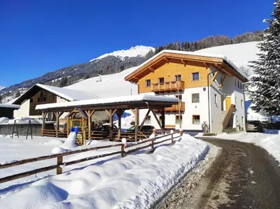 a house in the snow with a fence at Nestlhof in Vipiteno