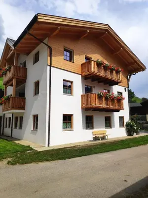 a building with wooden balconies and flowers on it at Nestlhof in Vipiteno