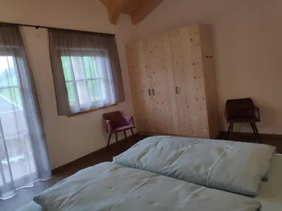 a bedroom with a bed and two chairs in it at Nestlhof in Vipiteno