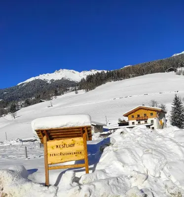 a sign in the snow in front of a building at Nestlhof in Vipiteno