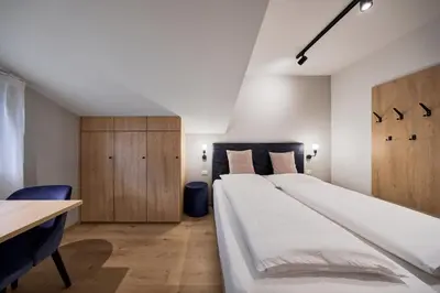 a large bed with white sheets and yellow pillows at Apartment Steinach in Lagundo