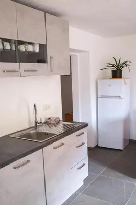 a kitchen with white cabinets and a sink at Panorama Latemar in Nova Levante