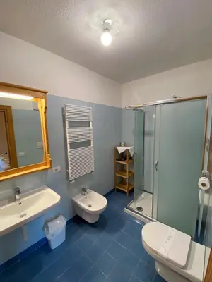 a bedroom with a large bed with two night stands at Rifugio Ospitale in Cortina dʼAmpezzo