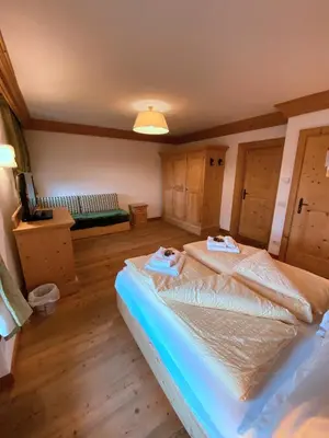 a bedroom with a bed and a table in a room at Rifugio Ospitale in Cortina dʼAmpezzo