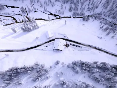 a dining room with two tables with white tablecloths at Rifugio Ospitale in Cortina dʼAmpezzo
