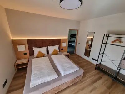 a bedroom with a large bed and a mirror at Appartement Mayr in Parcines