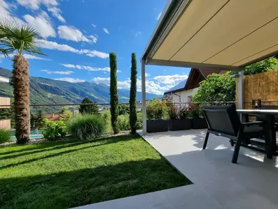 a patio with a table and a view of the mountains at Appartement Mayr in Parcines
