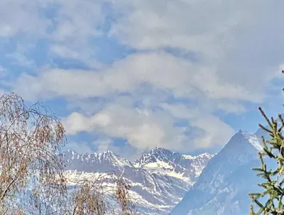 a city with a bridge over a river and mountains at Appartamento Pino a Merano centro con box in Merano