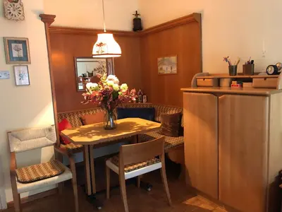 a dining room with a table with a vase of flowers at Appartamento Pino a Merano centro con box in Merano