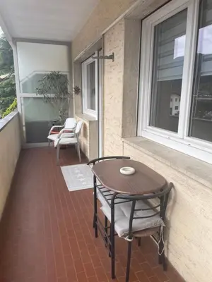 a porch with a table and chairs and a window at Casa Adriana in Bressanone