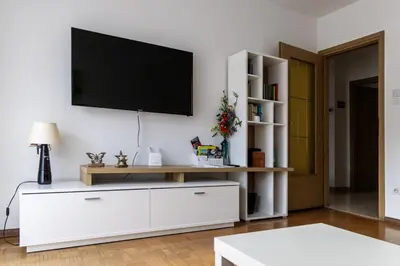 a living room with a tv on a white wall at Casa Adriana in Bressanone