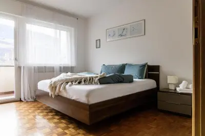 a bedroom with a large bed with a window at Casa Adriana in Bressanone
