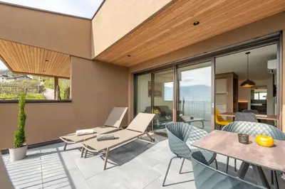 a patio with a table and chairs and glass doors at Apfelhof in Termeno
