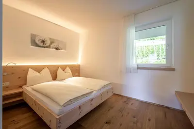 a bedroom with a bed in a room with a window at Apfelhof in Termeno