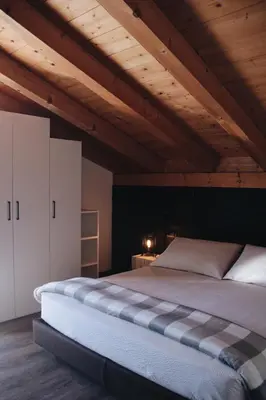 a large bed in a room with wooden ceilings at SAN ROMEDIO Agriturismo in Romeno