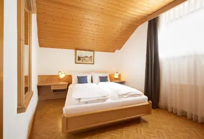 a bedroom with a bed and a wooden ceiling at Goldengel Ferienwohnung im Herzen Kalterns mit einer Terasse zum verlieben in Caldaro