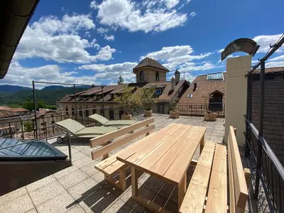 a patio with a wooden bench on a roof at Goldengel Ferienwohnung im Herzen Kalterns mit einer Terasse zum verlieben in Caldaro