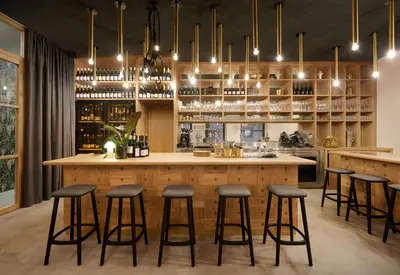 a kitchen with a bar with bar stools at Goldengel Ferienwohnung im Herzen Kalterns mit einer Terasse zum verlieben in Caldaro