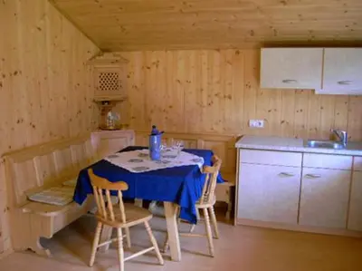a kitchen with a table and two chairs and a sink at Ferienhaus-Grünfelder in Luson