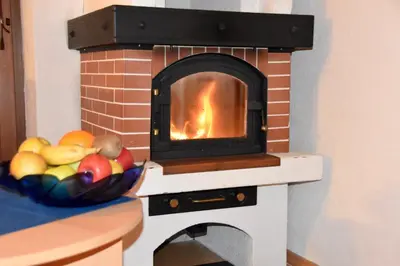 a brick oven with a bowl of fruit on a counter at Ferienhaus-Grünfelder in Luson