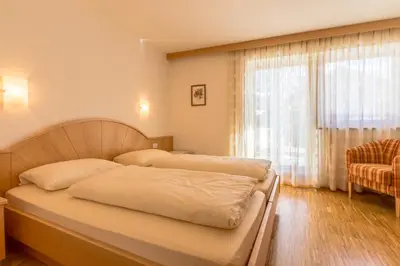 a living room with a table with chairs and a television at Ciasa Dolomites in La Villa