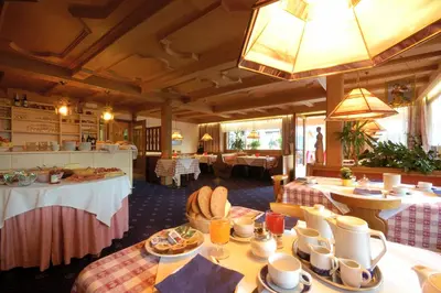 a dining room with tables and plates of food at Hotel & Residenz Traubenheim in Nalles